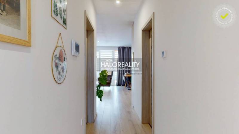 A hallway in a 3-room apartment with wooden flooring and decorations on the walls.