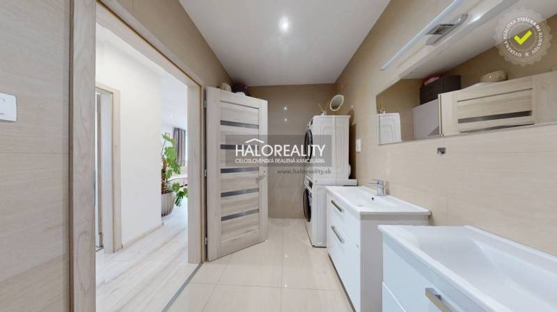 A bathroom in a 3-room apartment with two sinks and a washing machine.