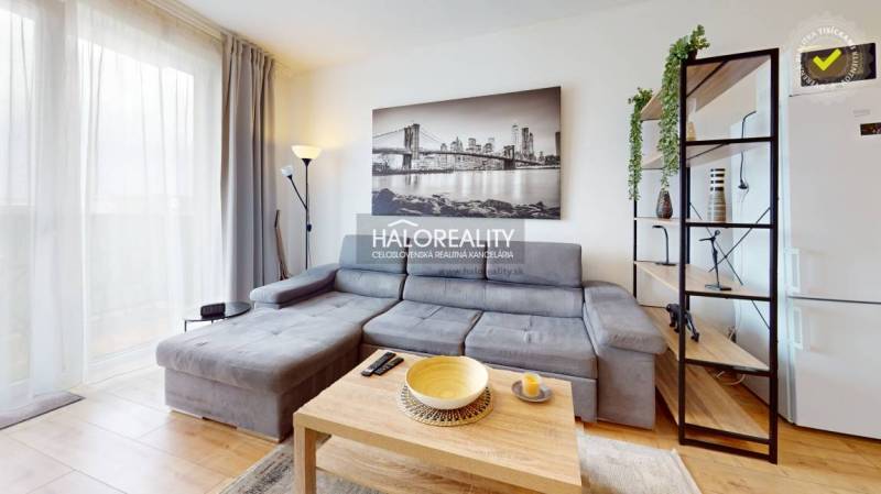 A stylish studio apartment with a sofa, decorative painting, and a bright interior.