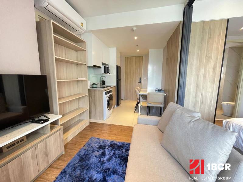 2-room apartment with a sofa, kitchenette, and dining table, light floor.
