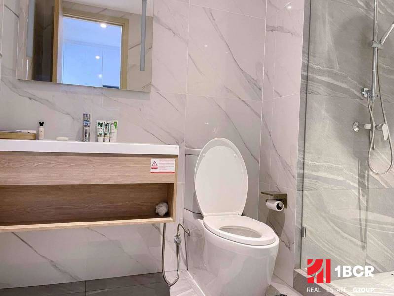 Bathroom in a 2-room apartment with white walls, a mirror, and a shower.