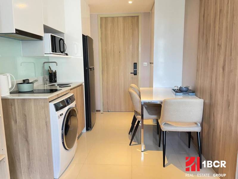 Kitchen in a 2-room apartment with a dining table and appliances.
