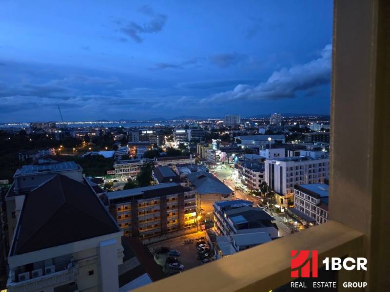 Evening view of the illuminated Pattaya skyline from a studio apartment.