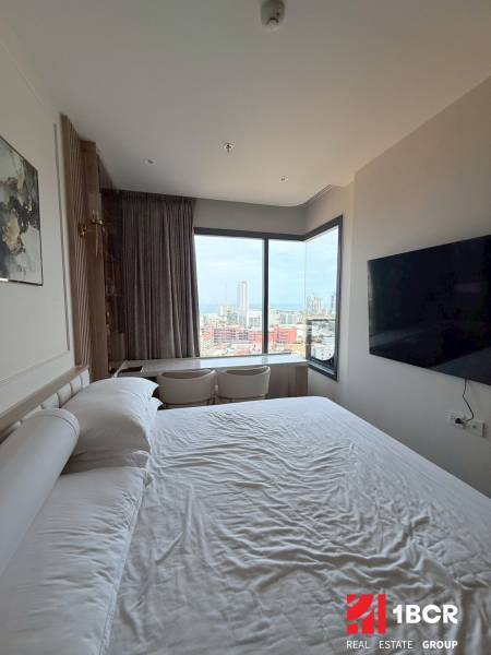 Bedroom in a 3-room apartment with a view of the city, large bed and TV.