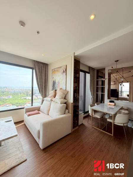 Living room in a three-room apartment, light walls, large window, dining table.