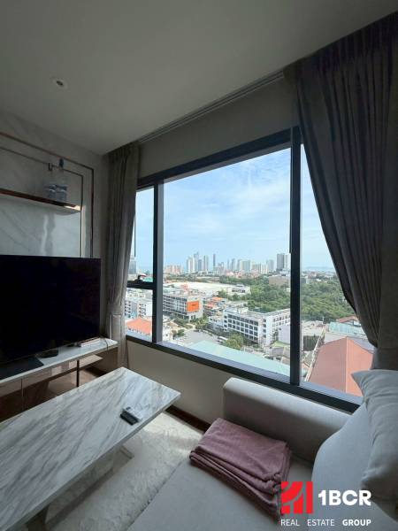 Living room of a 3-room apartment with a view of the city, a comfortable couch, and a TV stand.