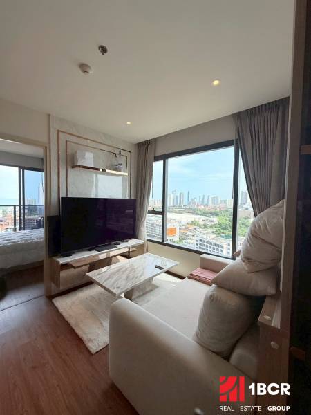 Living room in a 3-room apartment with a view and a large TV.