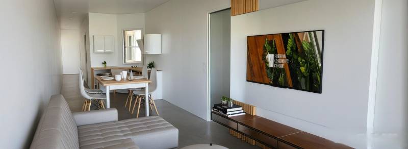 Living room in a 3-room apartment with a sofa, dining table, and television.