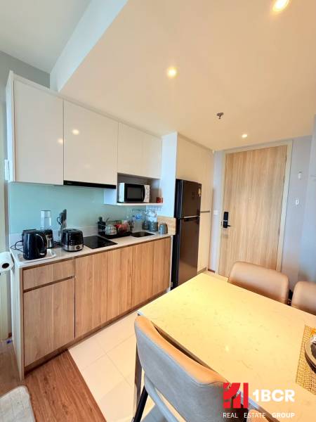 A kitchen in a 3-room apartment with wooden furniture and modern appliances.
