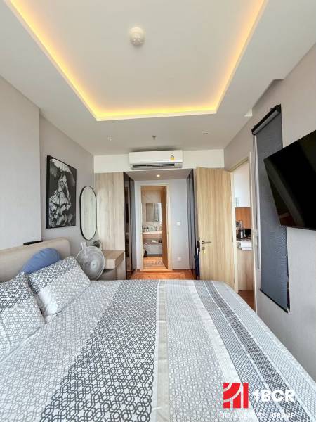 Bedroom of a 3-room apartment with patterned bedding, a mirror, and air conditioning.