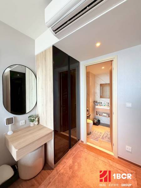 A corner with a mirror and a table in a 3-room apartment. In the background, there is a bathroom.