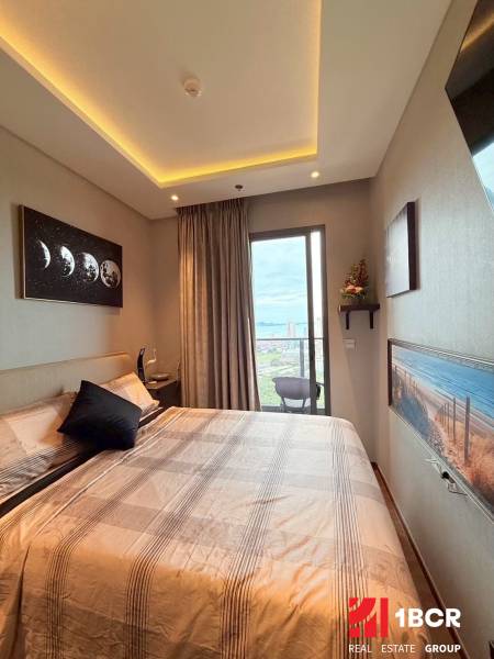 Bedroom in a 3-room apartment with a balcony, a large bed, and artistic paintings.