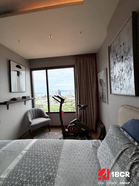 Bedroom in a 3-room apartment with a stationary bike and a view of the city.