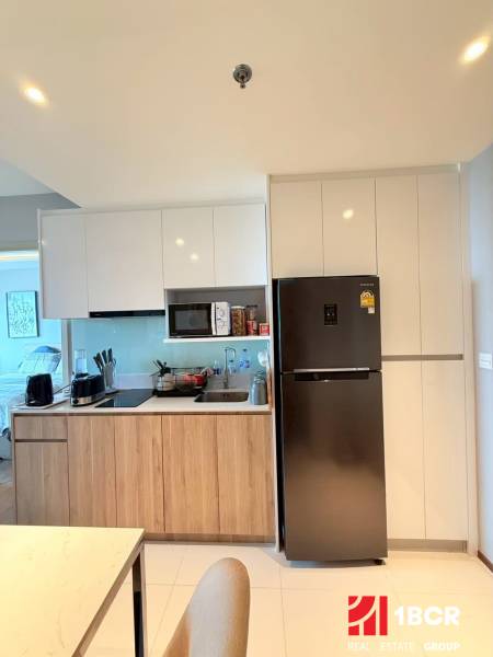 A kitchen in a 3-room apartment with wooden cabinets and a refrigerator.