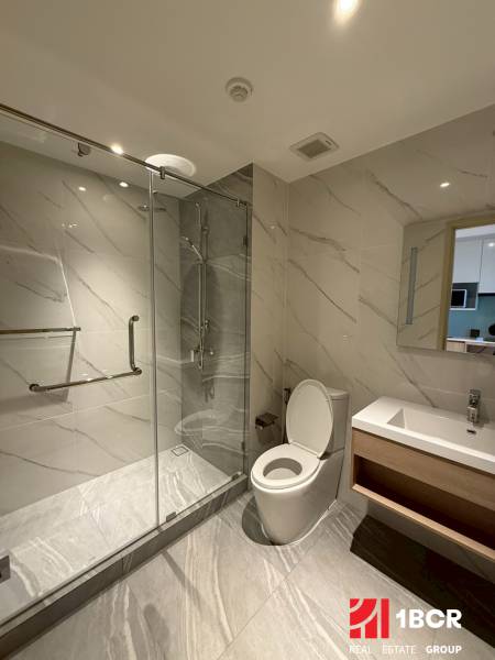 Bathroom with a shower and a sink in a studio apartment.