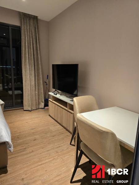 Interior of a 1-room apartment with a table, chairs, television, and curtains. Without mentioning the city.