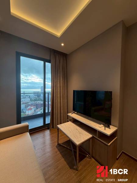 Living room in a 3-room apartment with a sofa, TV stand, and a view of the city.