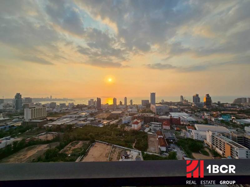 View from a 3-bedroom apartment in Pattaya of the sunset over the city and the sea.