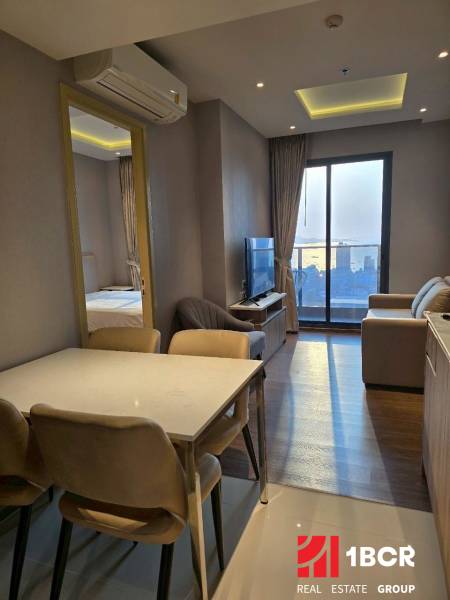 Dining area in a 3-room apartment with a view of the living room and balcony.