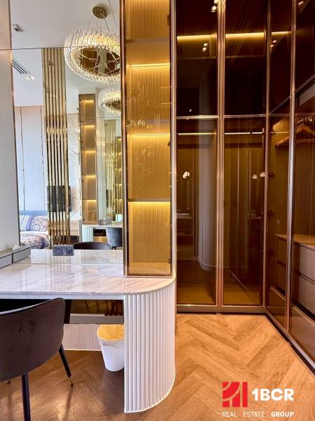 A wardrobe with lighting, a mirror, and a table in a 4-room apartment.