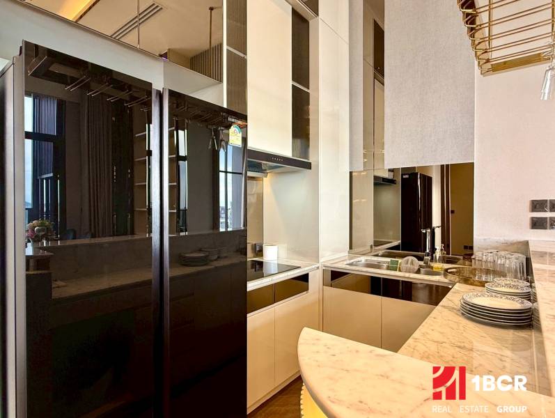 A kitchen in a 4-room apartment, with a marble countertop and a mirrored refrigerator.