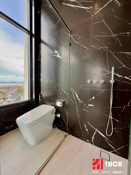 A bathroom in a 4-room apartment with marble walls and a view of the city.