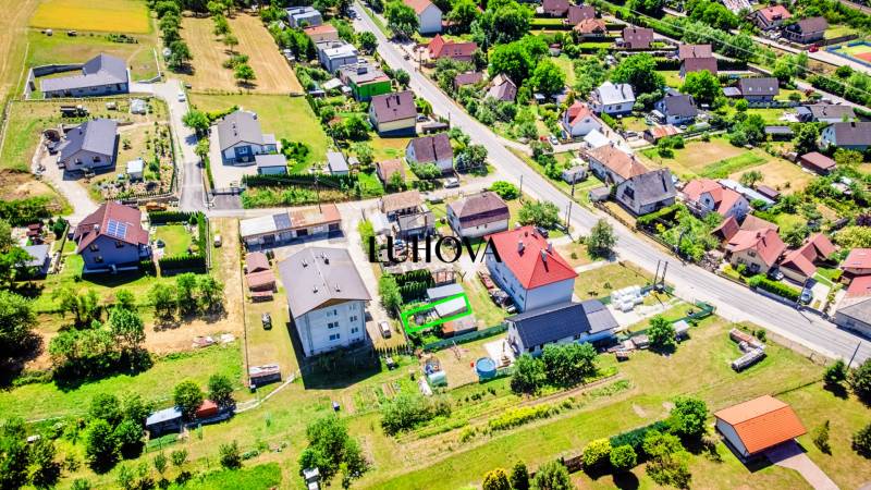 Aerial view of a residential area in Púchov, surrounded by greenery and roads.
