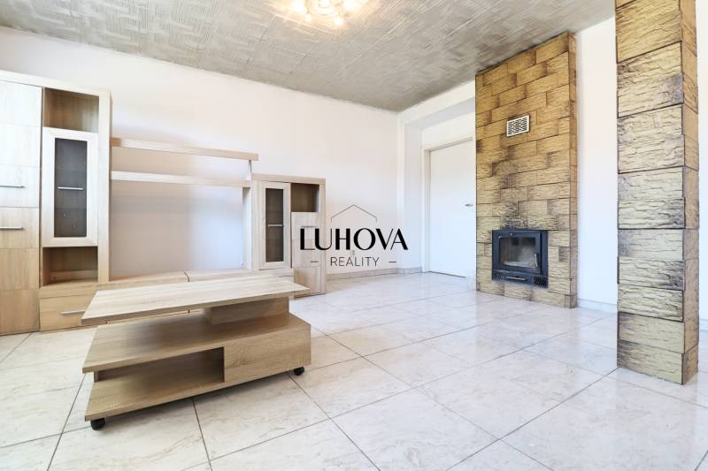 Living room with a fireplace stove and light furniture in a two-room apartment.