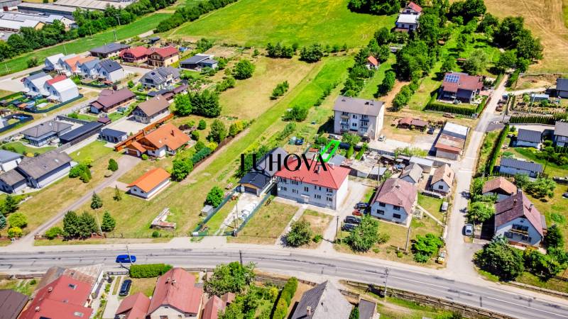 Aerial view of houses in Púchov with surrounding greenery and road infrastructure.