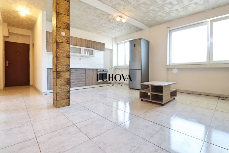 Spacious kitchen with built-in appliances in a 2-room apartment, tiles, large windows.
