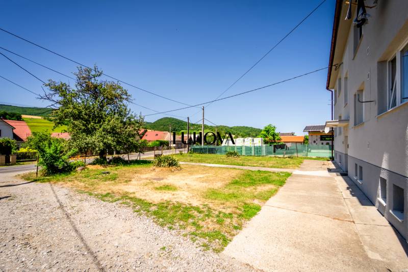 A family house in Púchov, surroundings with a grassy plot and an asphalt road.