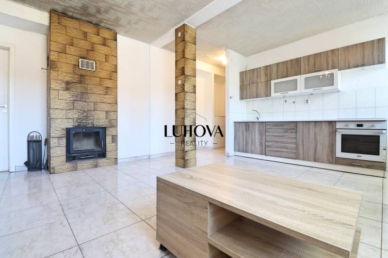 A spacious kitchen with a fireplace and furniture in a 2-room apartment.