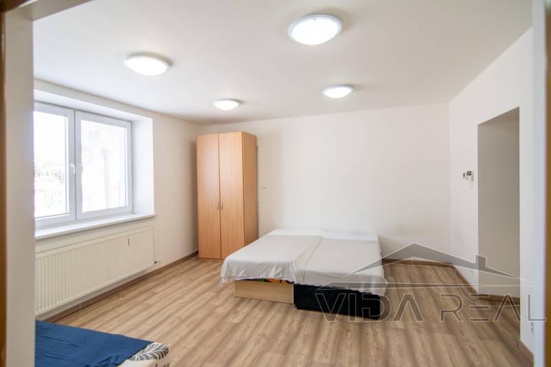 Bedroom with a bed, wardrobe, and window in a 2-room apartment.