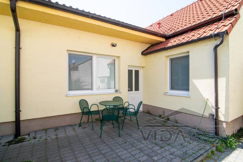 Yellow facade with a terrace and green furniture, 2-room apartment, Tulipánova, Trnava.
