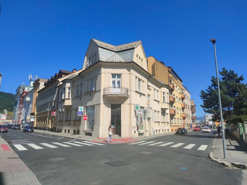 Intersection on Milcova Street in Žilina with commercial spaces and surrounding buildings.