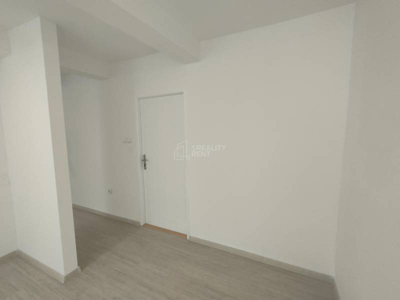 White walls and doors in commercial spaces with wooden flooring.