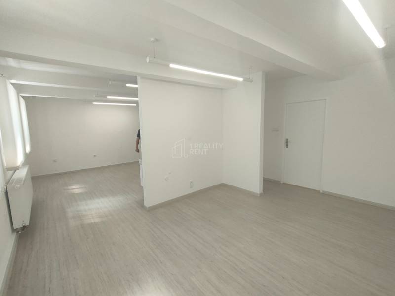 Bright commercial space with white walls and wooden flooring.