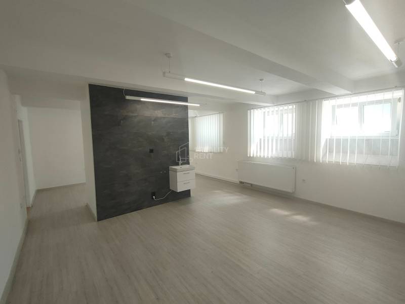 Commercial premises with wooden flooring and wall, vertical blinds on the windows.