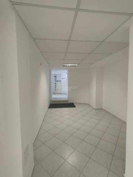 Brightly lit commercial spaces with tiled floors and white walls.