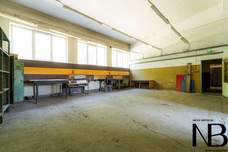 Spacious interior, warehouses and halls, with work tables and storage shelves.