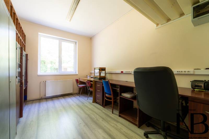 Office room with desks, chairs, and a cabinet in warehouses and halls.