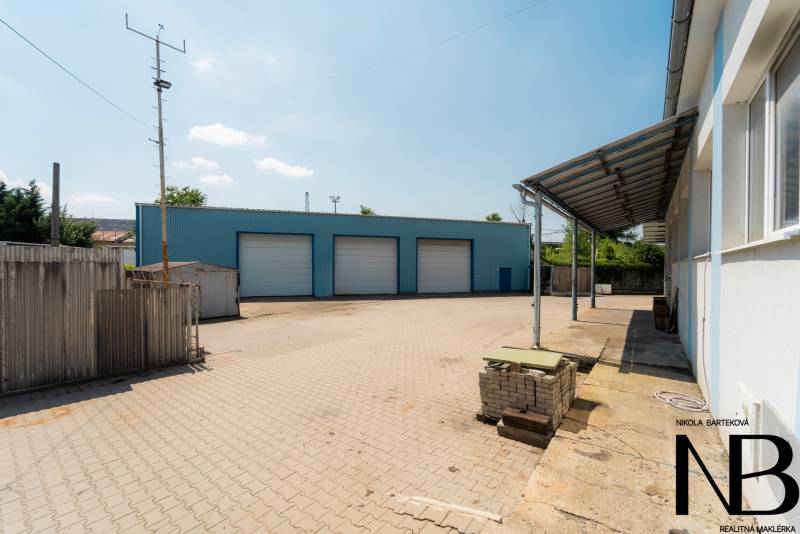 Warehouses and halls on Kasárenská Street in Trenčín with a reinforced area and a blue building.