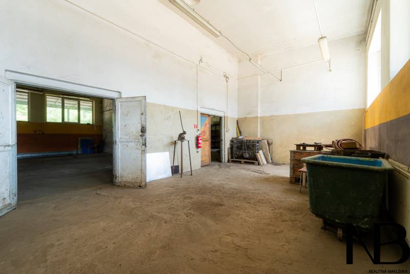 Production premises with old doors, metal tools, and a large waste container.