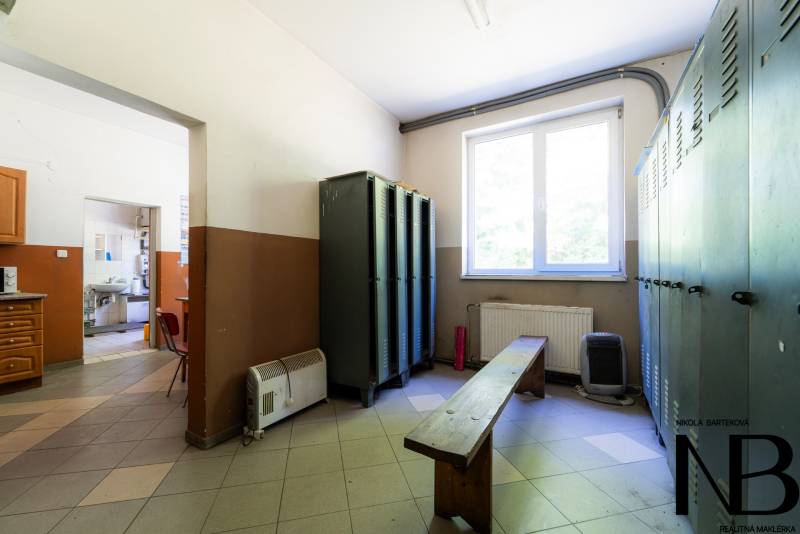 A locker room with lockers, a bench, and a window in the interior of unusual properties.