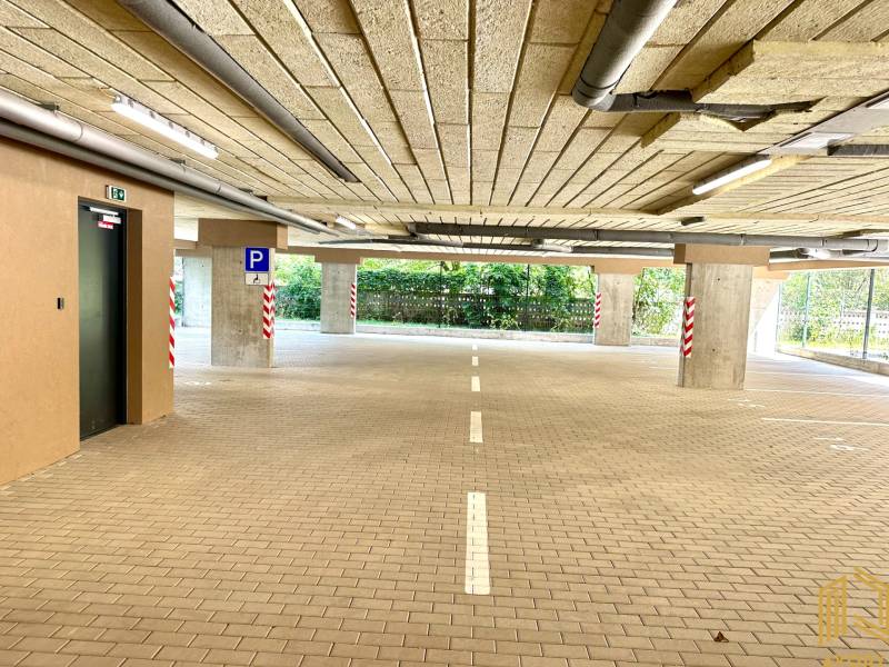 Parking garage with barrier-free access, illuminated and with marked parking spaces.