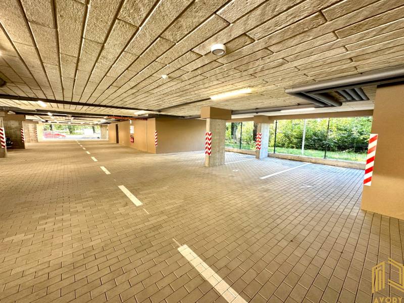 Garages with lights, parking spaces, and columns, Senica, Sadová, view of greenery.