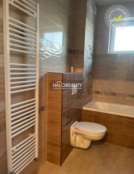 A bathroom in a 2-room apartment with a toilet, bathtub, and ladder radiator.
