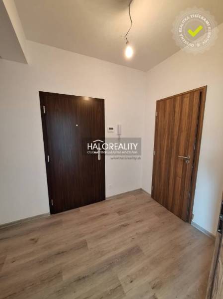 Entrance hall in a 2-room apartment with wooden flooring and doors.