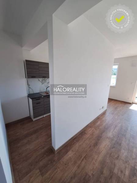 Wooden floor in a 2-room apartment with a kitchenette and a large window.