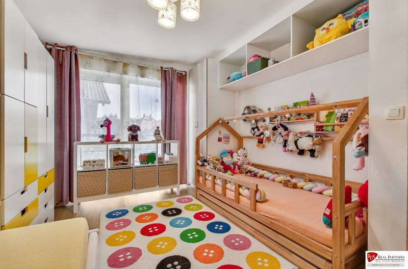 A children's room in a family house with toys and a colorful carpet.